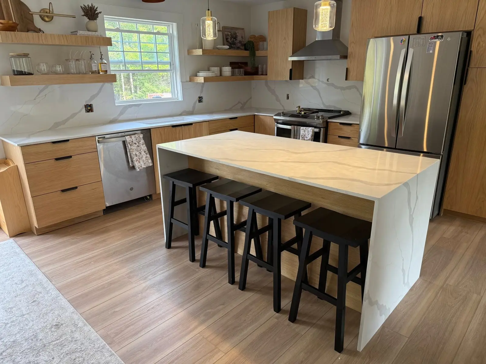 Waterfall island with a full-height slab backsplash in an oak kitchen