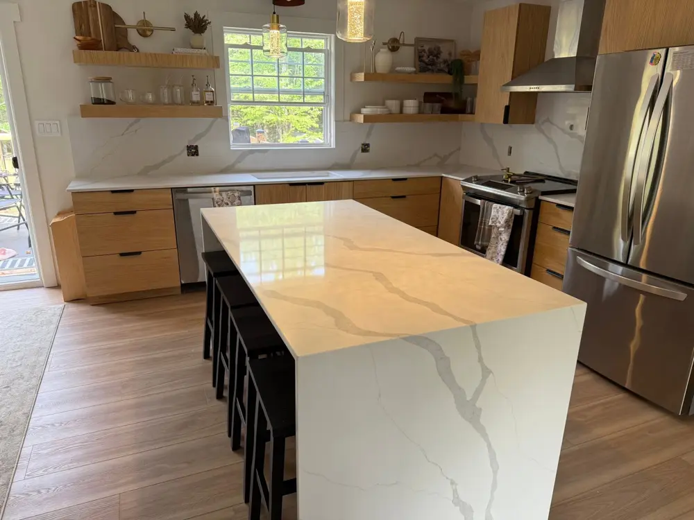 Waterfall island and full-height slab backsplash in an oak kitchen